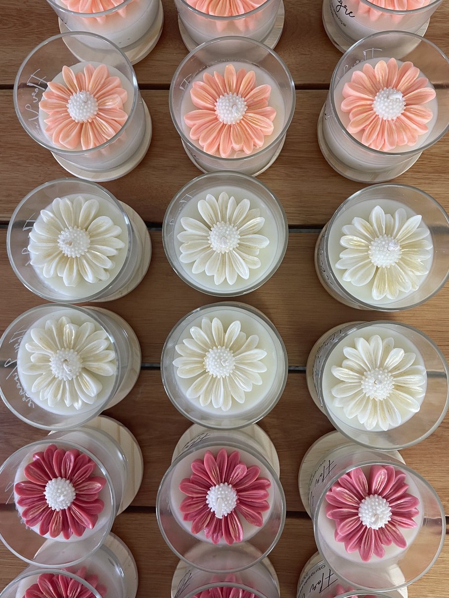 Detalhe das margaridas de cera sobre as velas